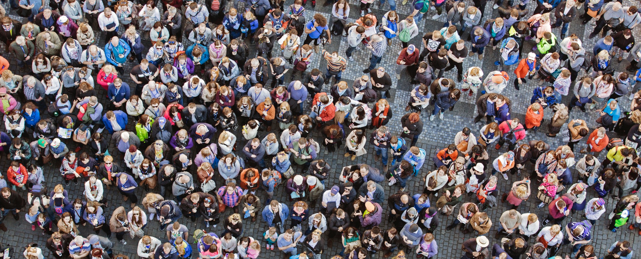 Aerial view of a diverse crowd of people, representing the concept of national sampling stratified by wealth and income brackets for research on economic mobility