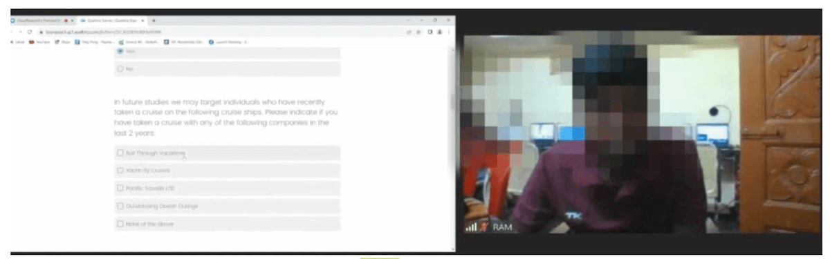 Screenshot from a video call showing inside a survey click farm with a participant visible and multiple computers in the background where other people are taking surveys, demonstrating how click farms operate with multiple devices to fraudulently complete online research surveys