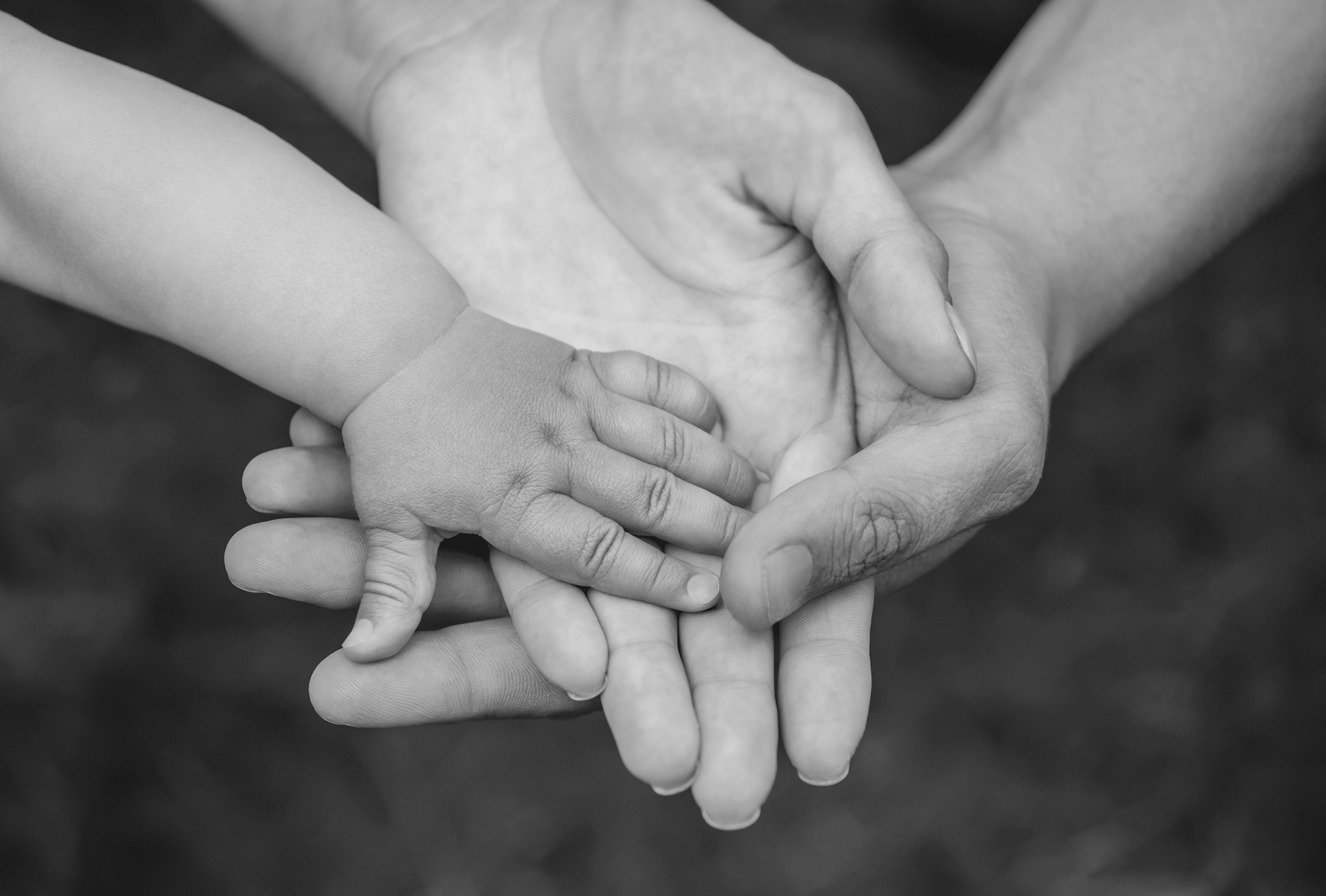 Three hands of the same family - father mother and baby stay together. Close-up.